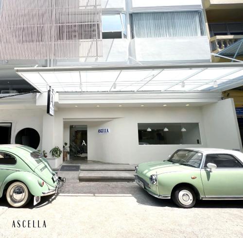 MakkasanにあるAscella Bangkok Hotelの建物前に停車したグリーンカー2台