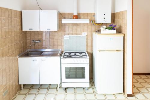 a kitchen with a white stove and a sink at Residence Rainbow in Bellaria-Igea Marina