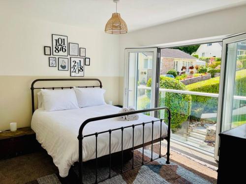 徹斯頓費斯的住宿－Beautifully presented holiday home near the beach，一间卧室设有一张床和一个大窗户