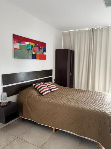 a bedroom with a bed and a black cabinet at Temporarios Sanatorios CENTRO in Rosario