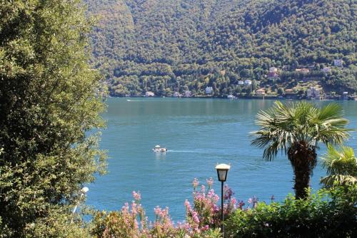 a view of a lake with a boat in the water at Lakeviewcabin - King Room With Balcony in Como