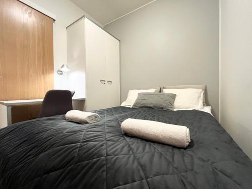 a bedroom with a bed with two pillows on it at Tammer Huoneistot - City Suite 3 - Public Sauna, Gym & Pool in Tampere