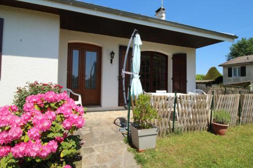 a small white house with an umbrella and flowers at Plaisance in Bujaleuf