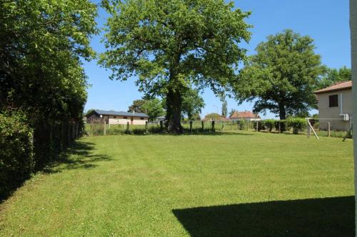 a large grassy yard with a tree and houses at Plaisance in Bujaleuf