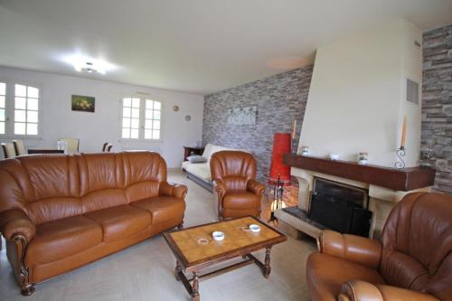 a living room with leather furniture and a fireplace at Plaisance in Bujaleuf