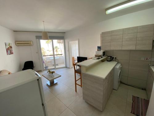 a kitchen with a counter and a table in a room at Alex Beach Apartment 203 in Larnaka