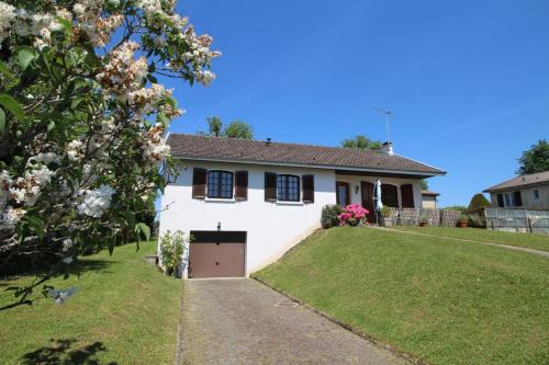 a white house with a garage in a yard at Plaisance in Bujaleuf