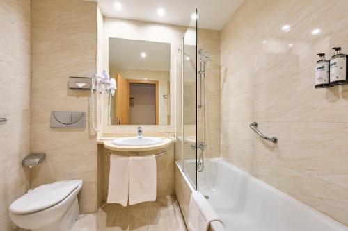 a bathroom with a sink and a toilet and a tub at Catalonia La Maquinista in Barcelona