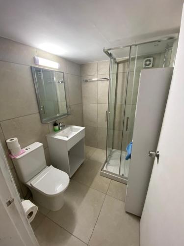 a bathroom with a toilet and a shower and a sink at Alex Beach Apartment 203 in Larnaka
