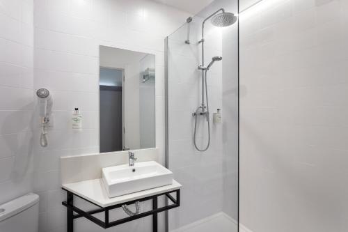 a white bathroom with a sink and a shower at B&B HOTEL Barcelona Mollet in Mollet del Vallès