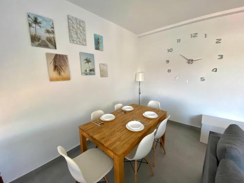 a dining room with a wooden table and white chairs at Apartamento ZAPILLO IRIA 1 in Almería