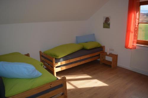 1 dormitorio con 2 camas individuales y ventana en Ferienwohnung Rißblick 
