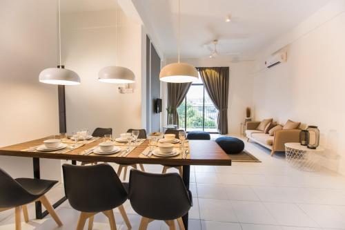 ein Esszimmer und ein Wohnzimmer mit Tisch und Stühlen in der Unterkunft ALOR SETAR IMPERIO PROFESSIONAL SUITE by Zenith Smart in Alor Setar