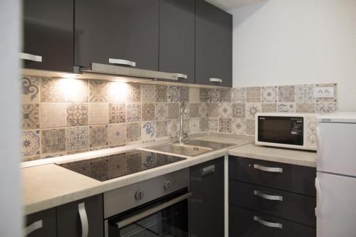 a kitchen with a sink and a microwave at Serious Job Apartment in Dubrovnik