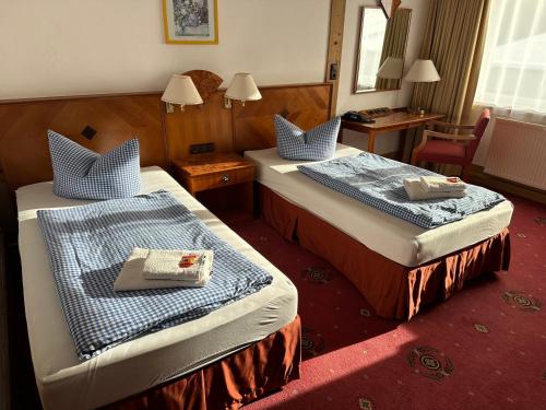 a hotel room with two beds and a mirror at Hotel Söllner in Tettau