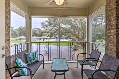 a screened in porch with chairs and a table at Diamondhead Condo - Marina, Pool Access and Golfing! in Diamondhead