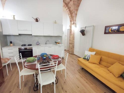 una cucina e una sala da pranzo con tavolo e divano di Delizioso trilocale in centro a due passi dal mare a Grottammare