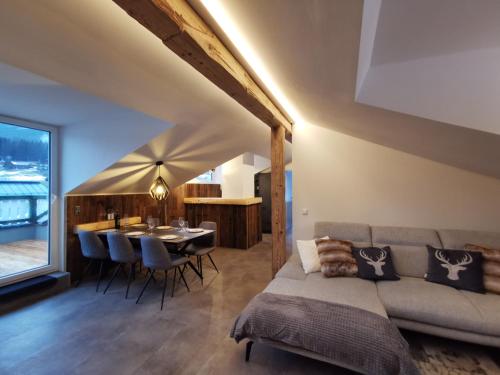 - un salon avec un canapé et une table dans l'établissement Panorama Lodge Edelweiss, à Gosau