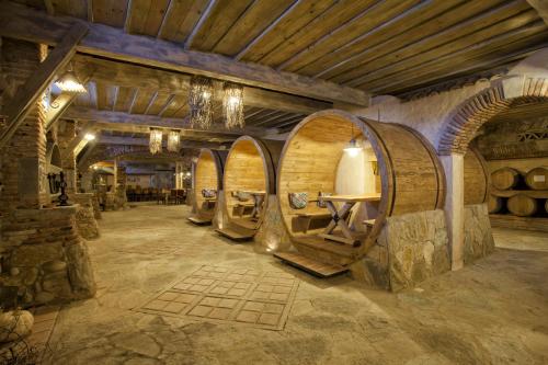 a wine cellar with a bunch of wine barrels at Ambassadori Kachreti Golf Resort in Kachretʼi