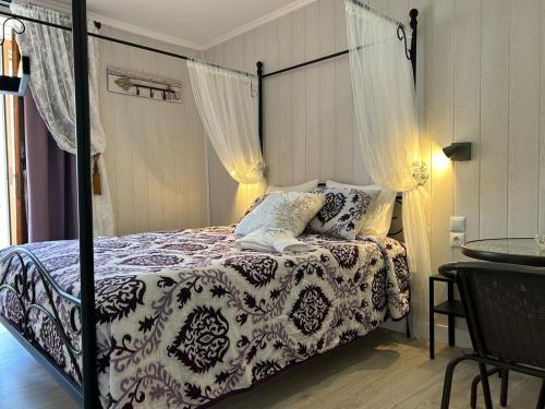 Schlafzimmer mit einem Bett mit einer schwarzen und weißen Bettdecke in der Unterkunft Charme da Graça in Lissabon