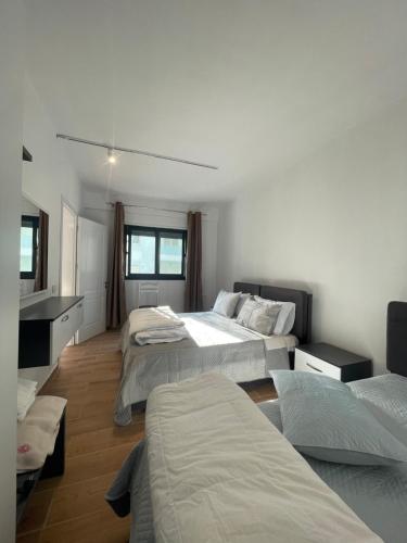 ein Schlafzimmer mit 2 Betten und einem Waschbecken darin in der Unterkunft Bonaparte apartments in Vlorë