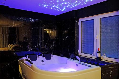 ein großes Bad mit einer Badewanne und einer violetten Decke in der Unterkunft Paradise HARMONY LUX Apt-New Belgrade in Belgrad