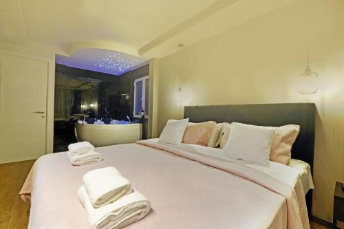 ein Schlafzimmer mit einem großen weißen Bett mit Handtüchern darauf in der Unterkunft Paradise HARMONY LUX Apt-New Belgrade in Belgrad