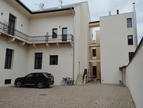 a car parked in a parking lot next to a building at Boutique Hotel Gaia in Kecskemét
