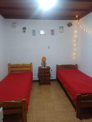 1 dormitorio con 2 camas y mesa con lámpara en Casahogar en Buenos Aires