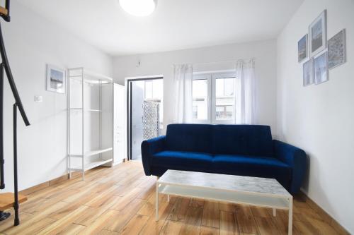 a living room with a blue couch and a coffee table at Domki Wierzbówka in Mielno