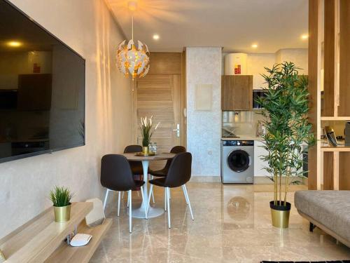a kitchen and living room with a table and chairs at Mogador Presidential Terrace - By AppartAli in Casablanca