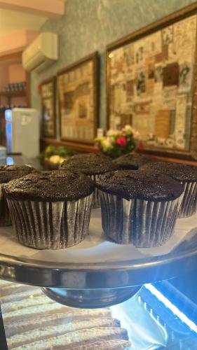three chocolate cupcakes on a plate on a table at The Historic Blue Moon Hotel - NYC in New York