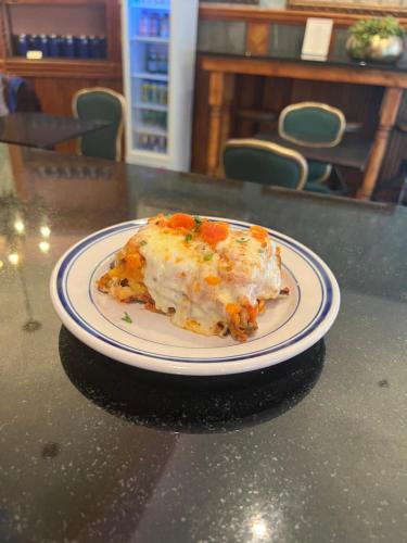 a slice of pizza on a plate on a table at The Historic Blue Moon Hotel - NYC in New York
