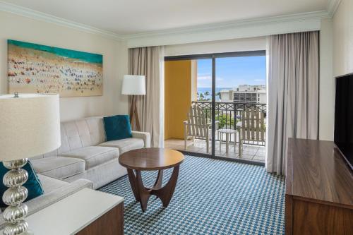 un soggiorno con divano e una camera con balcone di The Atlantic Suites on the Ave a Delray Beach