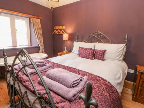 a bedroom with a large bed with purple walls at Manor House in Leyburn