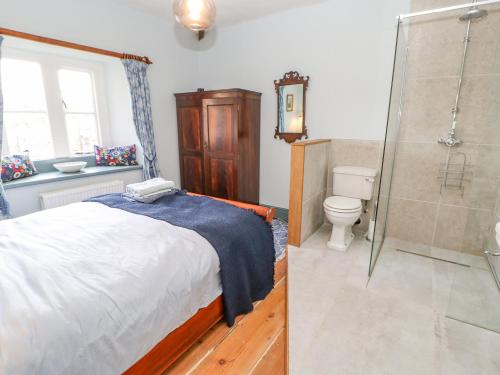 a bedroom with a bed and a shower and a toilet at Manor House in Leyburn