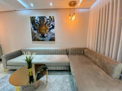 a living room with a couch and a painting of a tiger at Charming Top Floor Bourgogne - By AppartAli in Casablanca