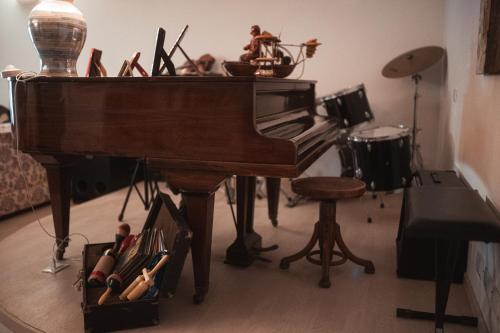 a piano in a living room with a chair and a stool at A casa di Asia in Viterbo
