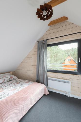 a bedroom with a bed and a window at Ostoja Notecka in Mężyk
