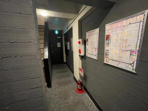 a hallway in a building with maps on the wall at Sincere Residence in Osaka