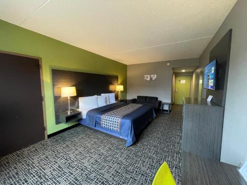 a hotel room with a bed and a flat screen tv at Wingate by Wyndham Lake George in Lake George