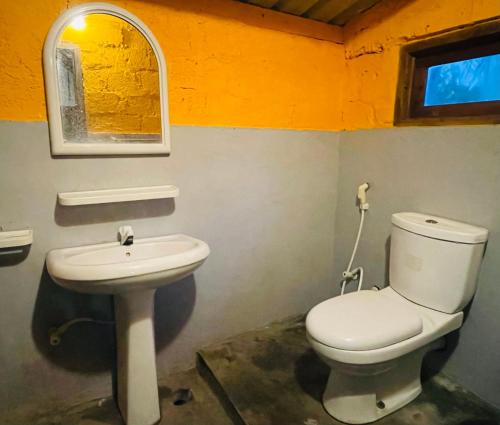 a bathroom with a toilet and a sink at Vitamin Sea Beach Cabana in Nilaveli