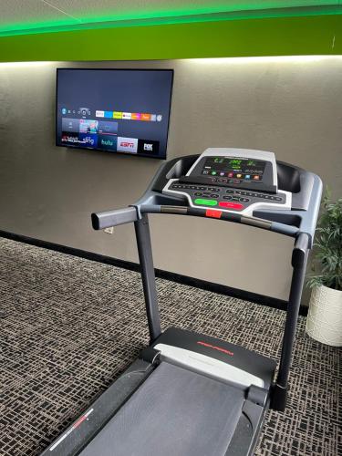 a treadmill in a room with a tv on a wall at Wingate by Wyndham Lake George in Lake George