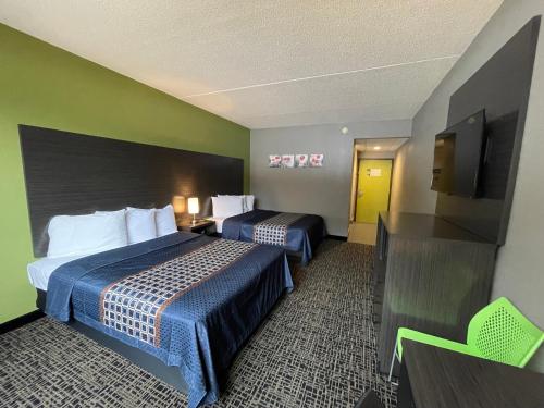 a hotel room with two beds and a flat screen tv at Wingate by Wyndham Lake George in Lake George