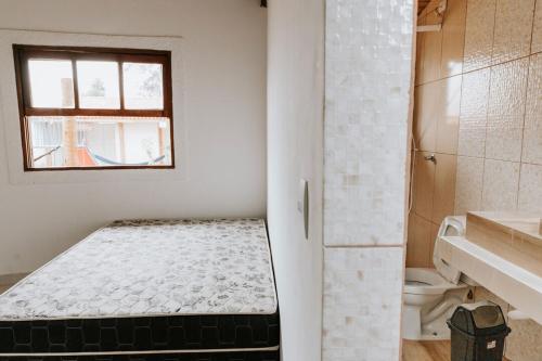 a small white room with a bed in a bathroom at Casa c conforto piscina e churrasqueira Atibaia in Atibaia