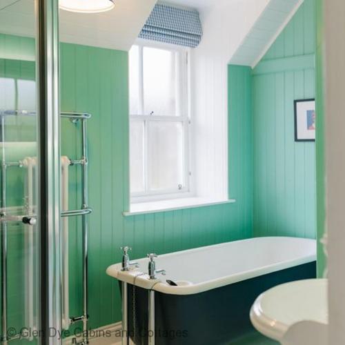 a green bathroom with a tub and a sink at Cuttieshillock in Banchory