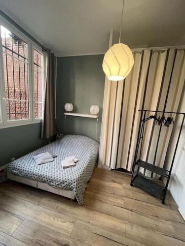une chambre avec un lit dans une pièce avec une fenêtre dans l'établissement LE GALET BLANC cosy T2 en centre ville du Havre, au Havre