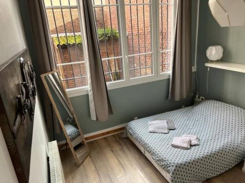 mały pokój z łóżkiem i 2 oknami w obiekcie LE GALET BLANC cosy T2 en centre ville du Havre w Hawrze