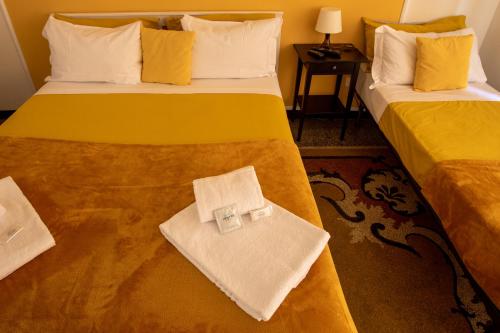 a hotel room with two beds with towels on them at Granello Suite Central in Genova