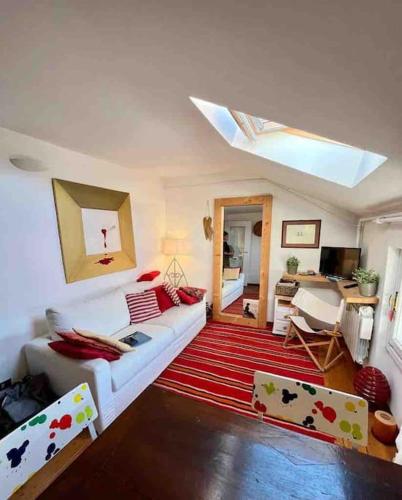 a living room with a white couch and a red rug at La Casa di Fede in Sauze dʼOulx
